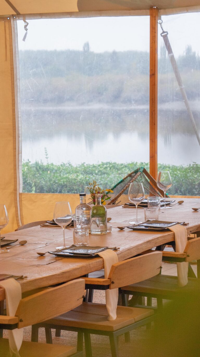 Gedekte tafel in de tent met zicht op de Schelde